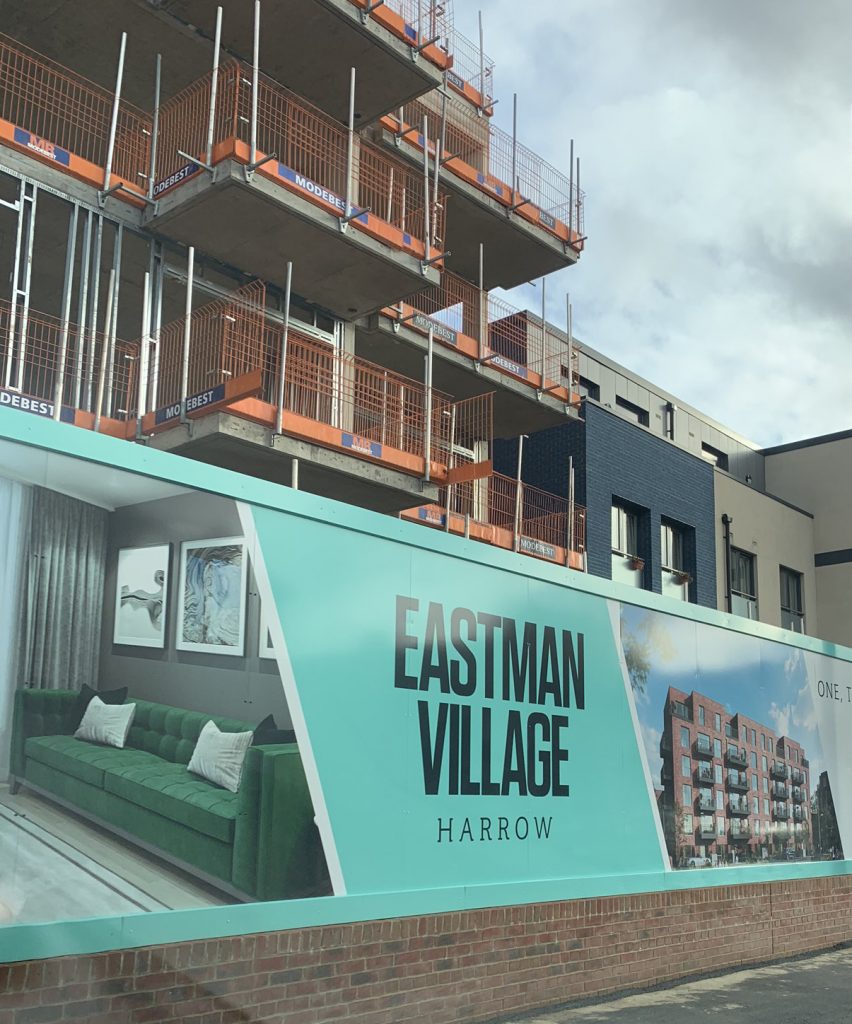 Eastman Village construction boarding showing property interior with curtains imagery