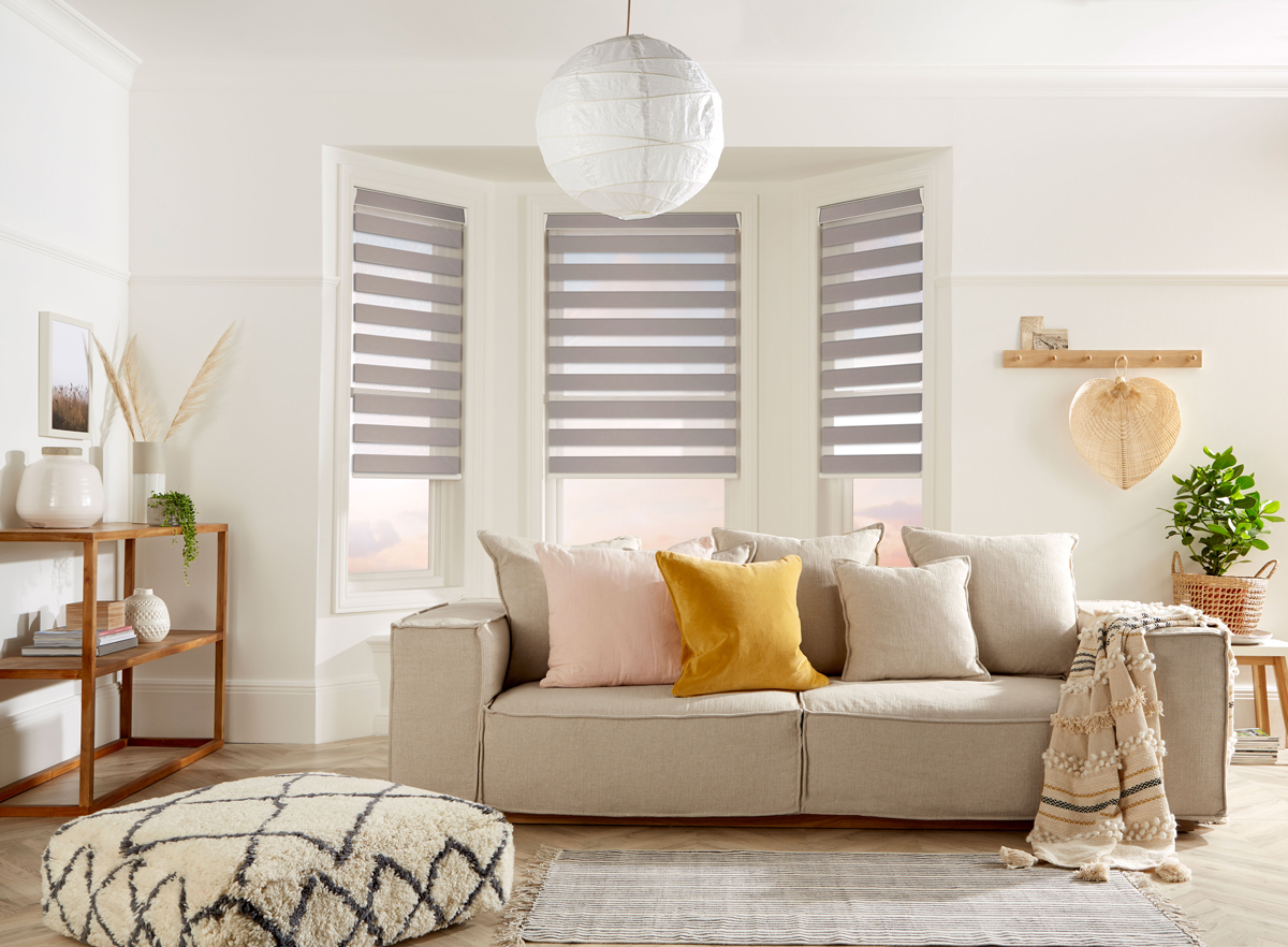 Bedroom window with dual layer zebra roller blind motorised for light control, casting striped shadows